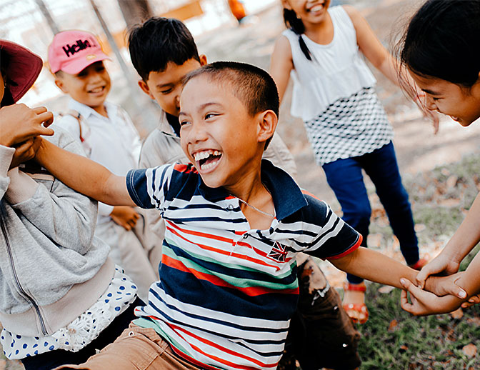 A laughing member of the Young Stars Club, playing with other children in the club.