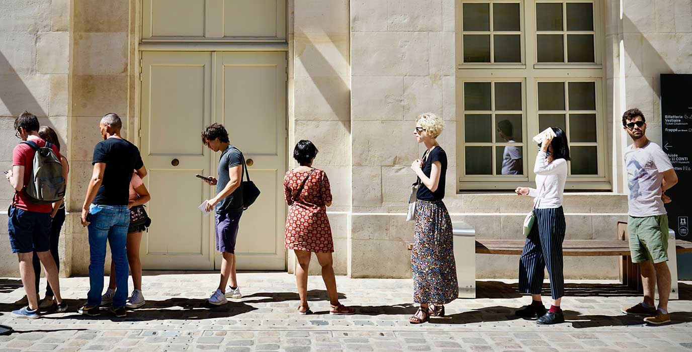 A line of people, waiting to get in to the museum.